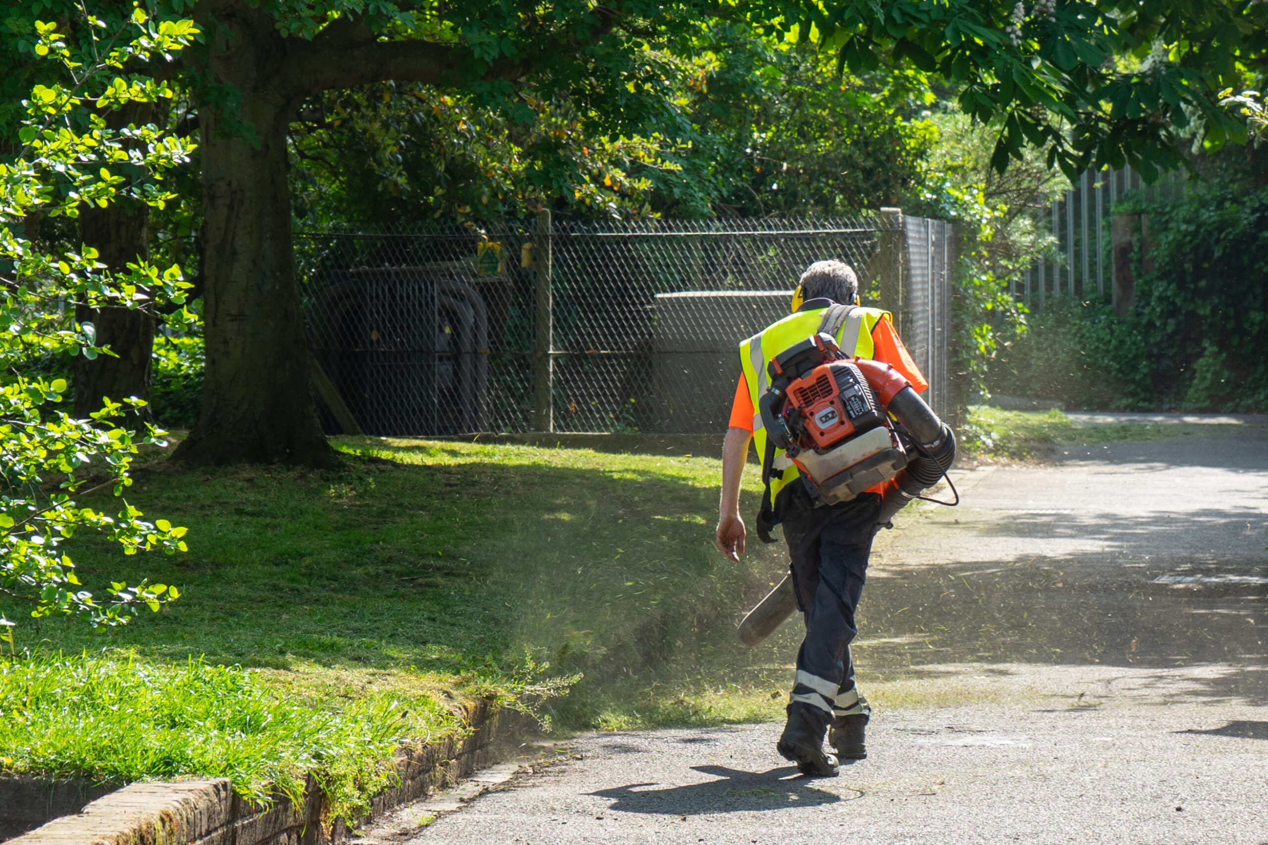 A,Landscape,Gardener,Using,A,Leaf,Blower,To,Blow,Away
